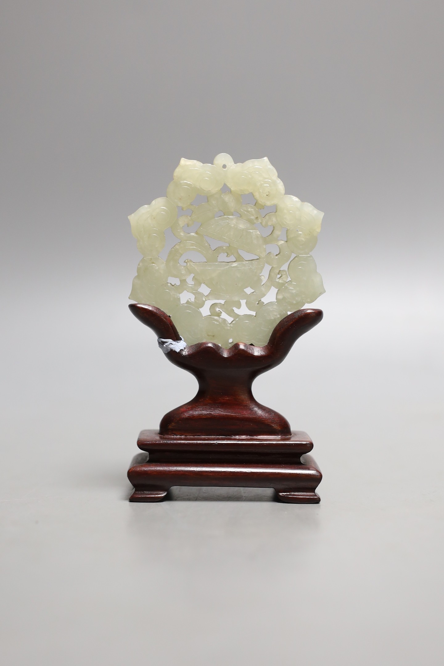 A Chinese pale celadon jade star shaped plaque, wood stand, 12cm